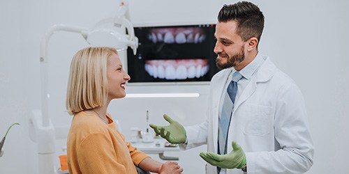 Dentist talking to smiling patient in office