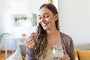 Woman smiling before taking a pill because it will promote her health